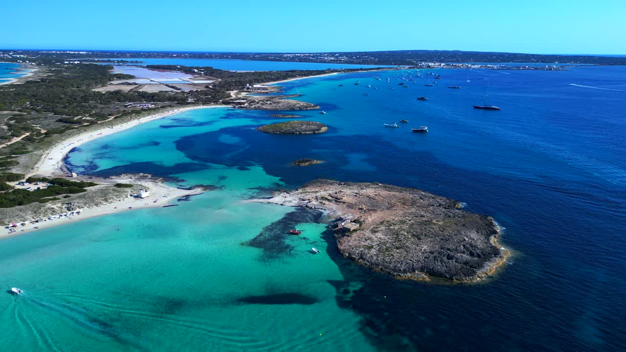 Formentera island landscape Ses Illetes beach bay with shallow blue turquoise sea and boats. Gorgeous aerial view descending panorama overview drone