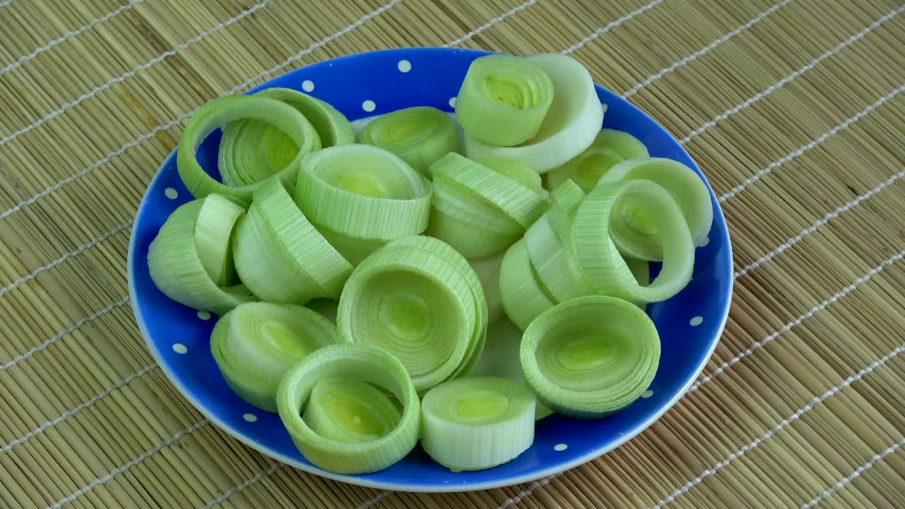 Rotating fresh cutted vegetable leek in plate