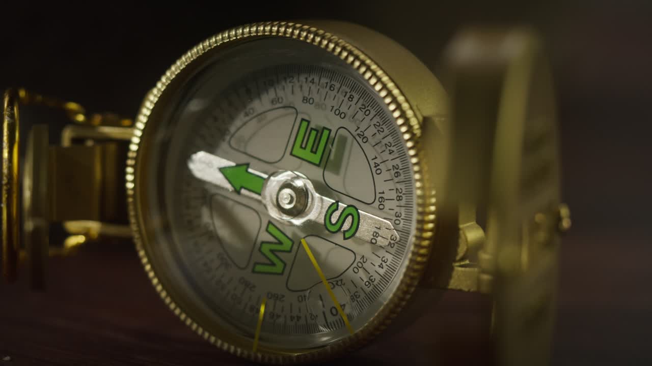 Gold compass close-up, golden compass on table. Traveling and tourism concept, navigation.