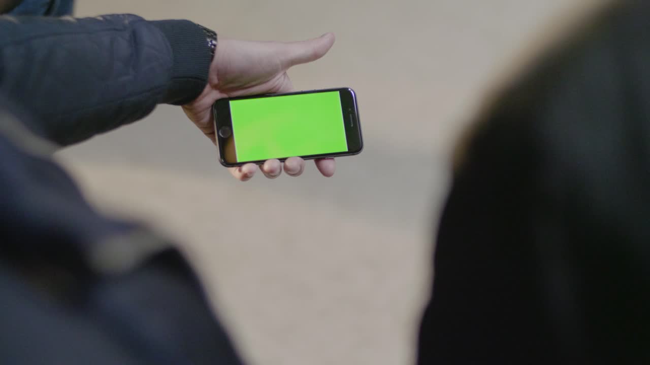 녹색 화면을 가진 스마트폰에서 토론하는 사람들