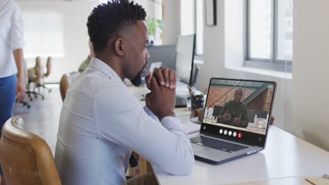Hombre-Afroamericano-Usando-Una-Computadora-Portátil-Para-Videollamadas,-Con-Un-Colega-De-Negocios-En-La-Pantalla
