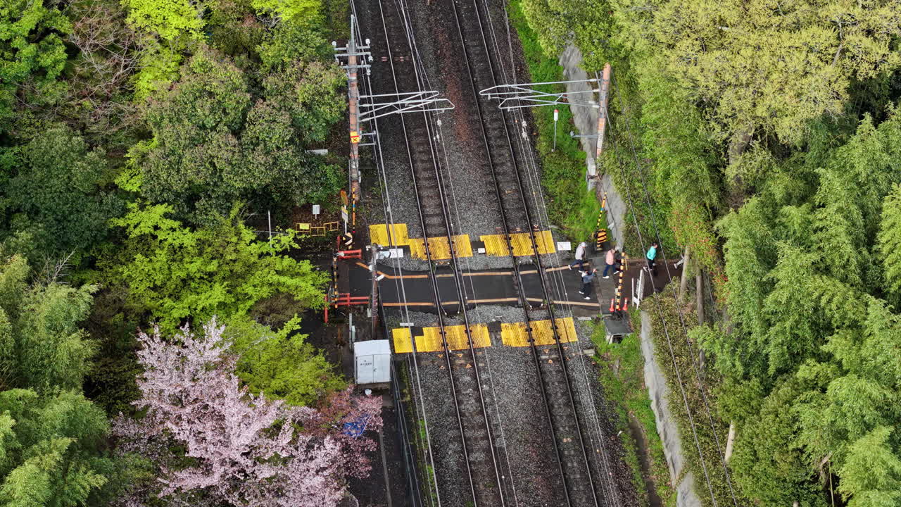 Aerial drone view of people crossing the railroad in Arashiyama, Japan