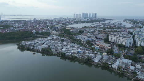 above pluit lake and slum neighborhoods in north jakarta drone rise and rotate