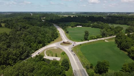 A roundabout in St. Thomas Ontario Canada showing people driving and the lush landscapes surrounding it