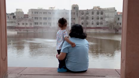 isolated-young-mother-and-cute-toddler-son-enjoying-togetherness-sitting-at-outdoor-at-evening