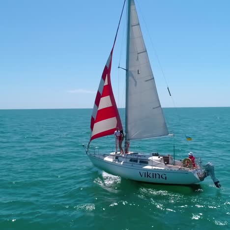 sailing on sailboats at sea bay. white sailing ship on water at cinematic drone shot