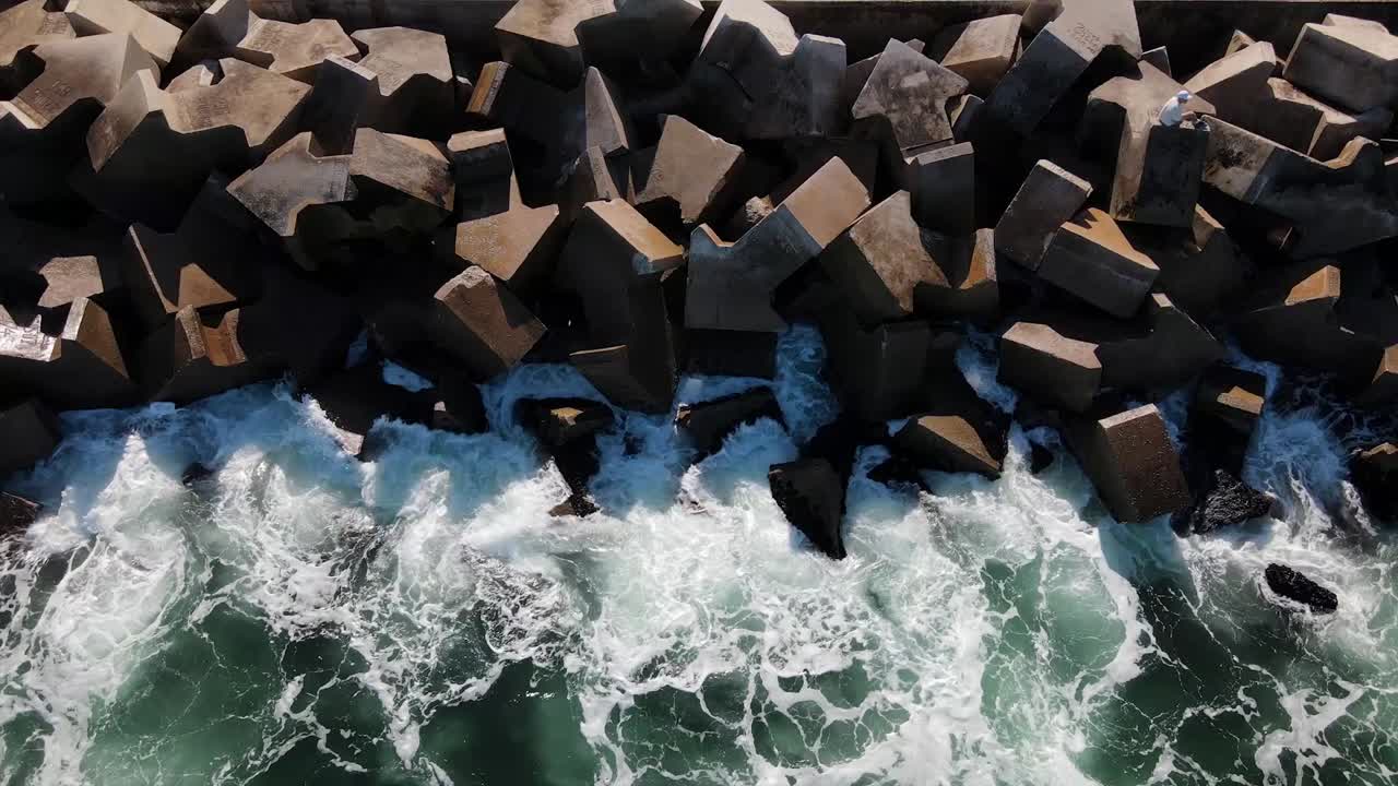 Breakwater of a harbour wall with waves lapping against it