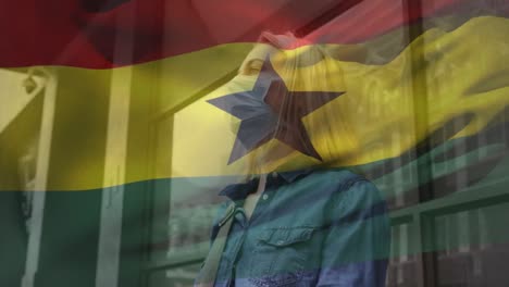 Animation-of-flag-of-ghana-waving-over-caucasian-woman-wearing-face-mask-in-city-street