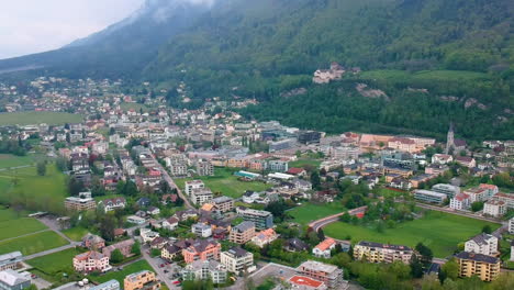 pintoresca vista de la ciudad de vaduz enclavada en las estribaciones de densas montañas en liechtenstein