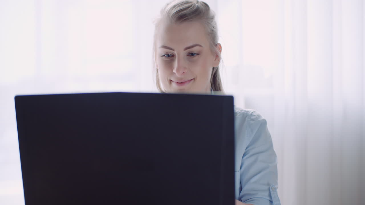 mujer sonriente que trabaja en la computadora portátil en la oficina en casa empresaria escribiendo en el teclado de la computadora 10