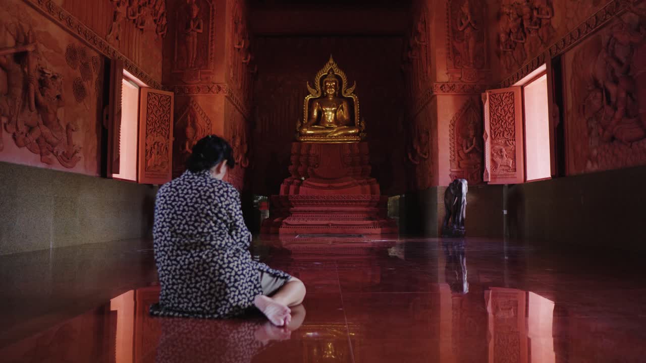 亞洲女子在泰國佛寺內祈禱
