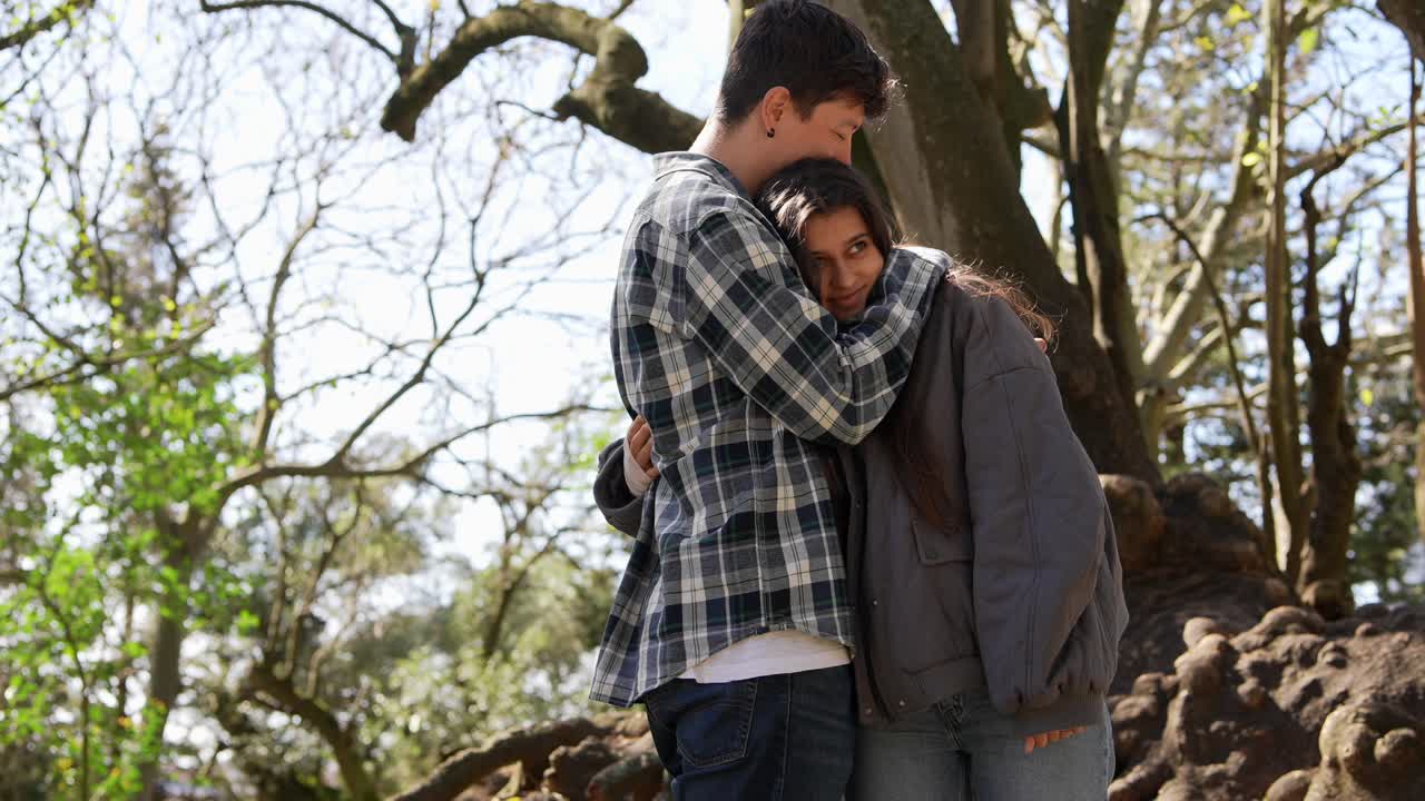 una pareja abrazándose en un parque.