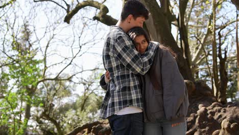 una pareja abrazándose en un parque.