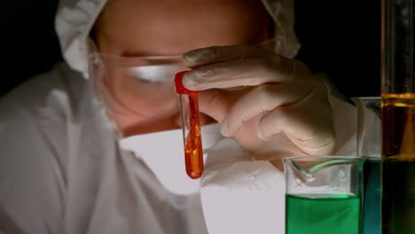 scientist swirling red liquid in test tube