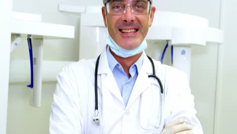 retrato de un dentista sonriente de pie con los brazos cruzados