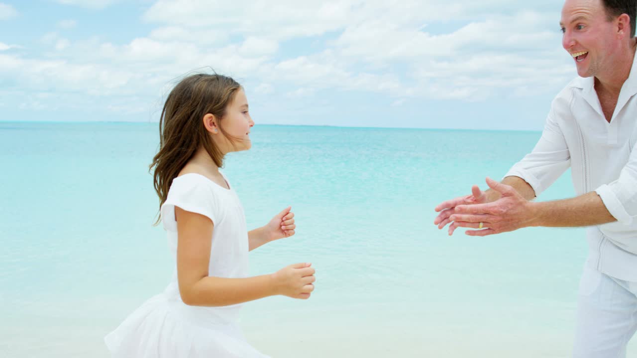 padres caucásicos con sus hijas en una playa tropical