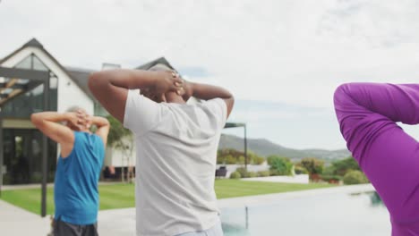 Senior-diverse-people-practicing-yoga-in-garden-at-retirement-home