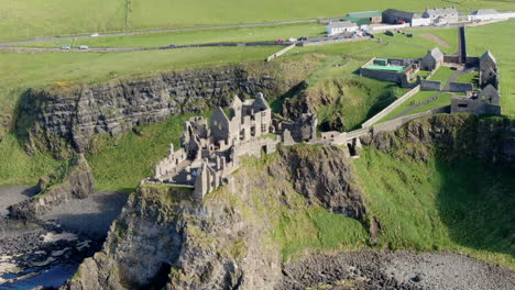 fantastic aerial shot in orbit over dunluce castle in ireland, the setting for the game of thrones series