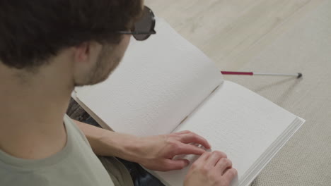 Top-view-of-caucasian-young-man-touching-a-book