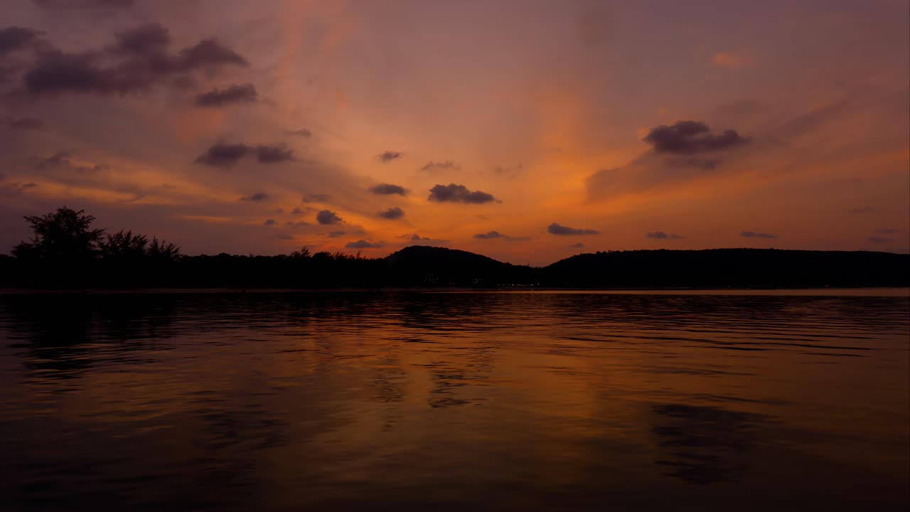 Stunning sunset time lapse over the sea with mountain on the background