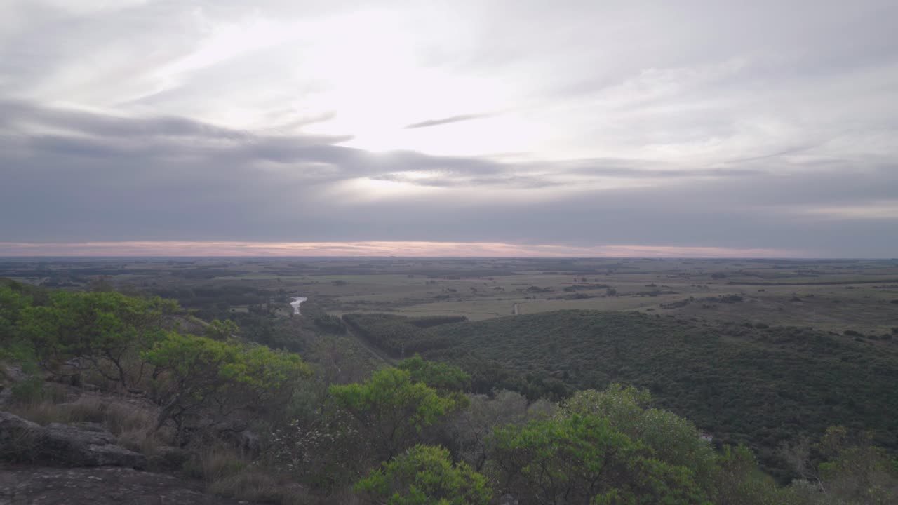 Young woman runs on top of the mountain. You can see a beautiful landscape of relives at sunset.