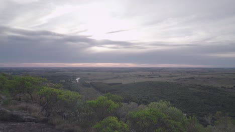 young woman runs on top of the mountain. you can see a beautiful landscape of relives at sunset.
