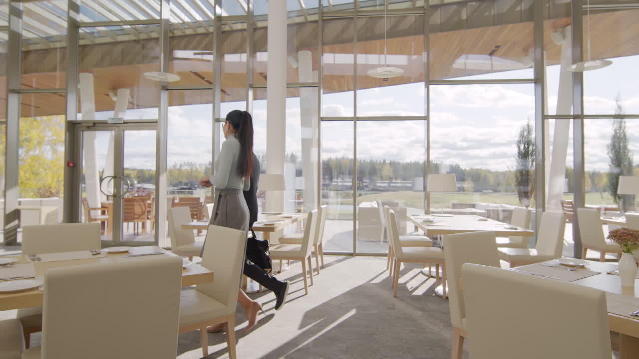 Business Colleagues Walking Through a Modern Restaurant with Large Windows