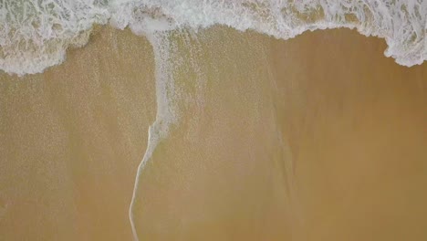 Slow-flight-over-isolated-beach-and-waves-in-wild-colorful-ocean,-Australia