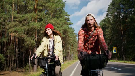 couple cycling through the forest