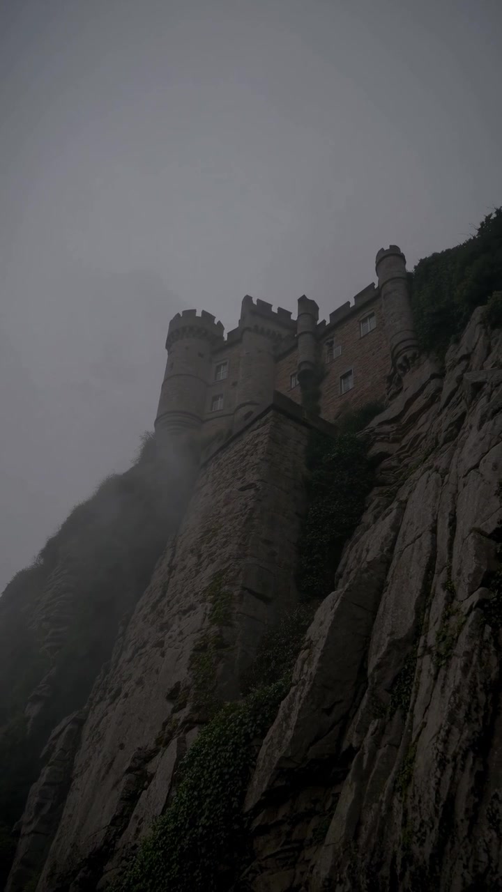 Lâu đài Gothic trên vách đá gồ ghề chìm trong màn sương bí ẩn.