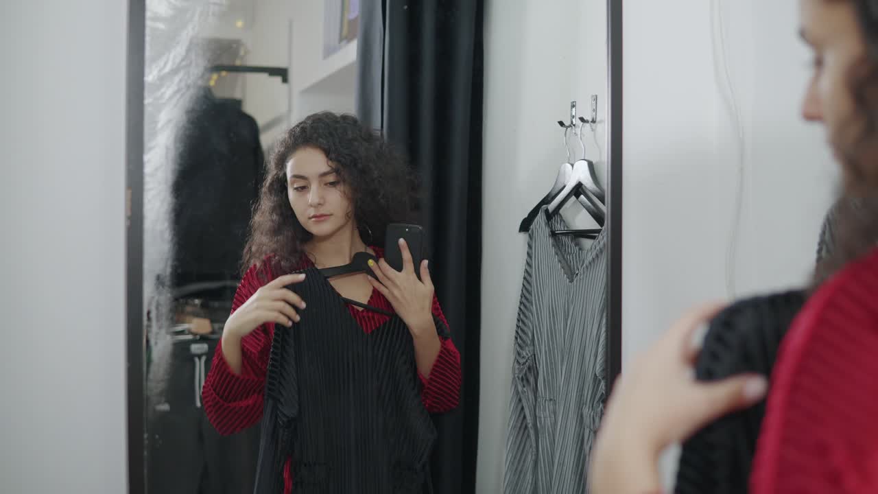 여자 가 착용실 에서 드레스 를 착용 하고 있다