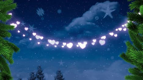 animation of fairy lights, fir tree decoration, snow falling over blue sky