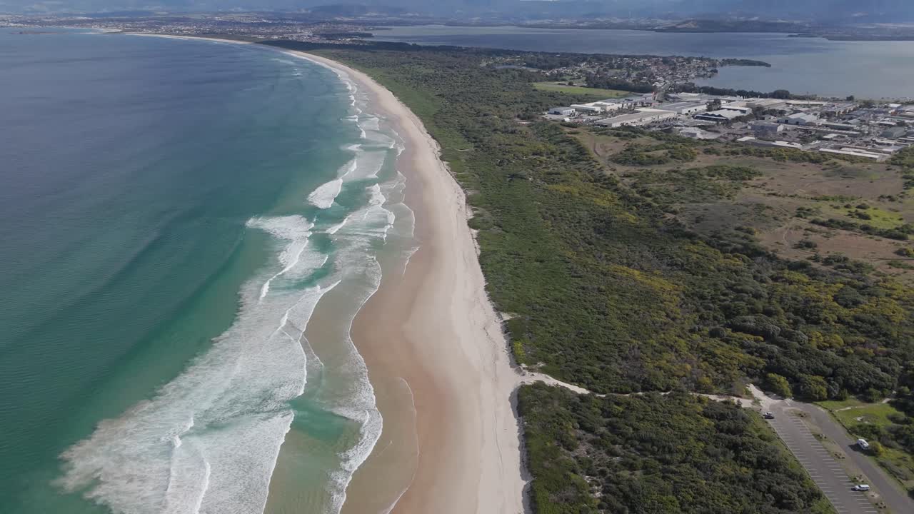 드론은  모래 해변을 뒤로 하고, 아름다운 푸른 날에 지평선으로 휘어져, 바다의 파도가 부히고 해안으로 굴러갑니다. - 포트 블라, nsw, 오스트레일리아