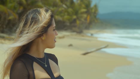 close up of a girl smiling and walking in the sand with her hair blowing in the wind