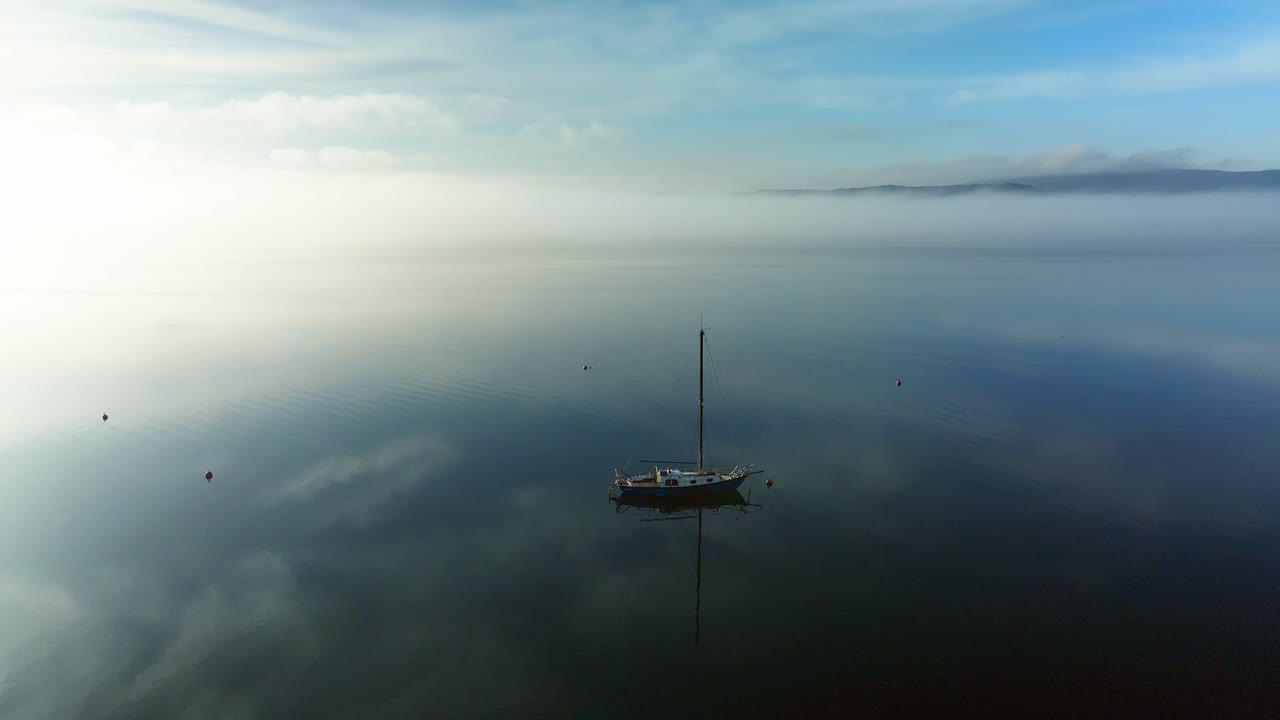 백그라운드에서 태양 빛나고 세일링 요트 주위에 영화 드론 비행