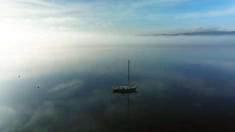 cinematic drone flight around sailing yacht with sun shinning in the background