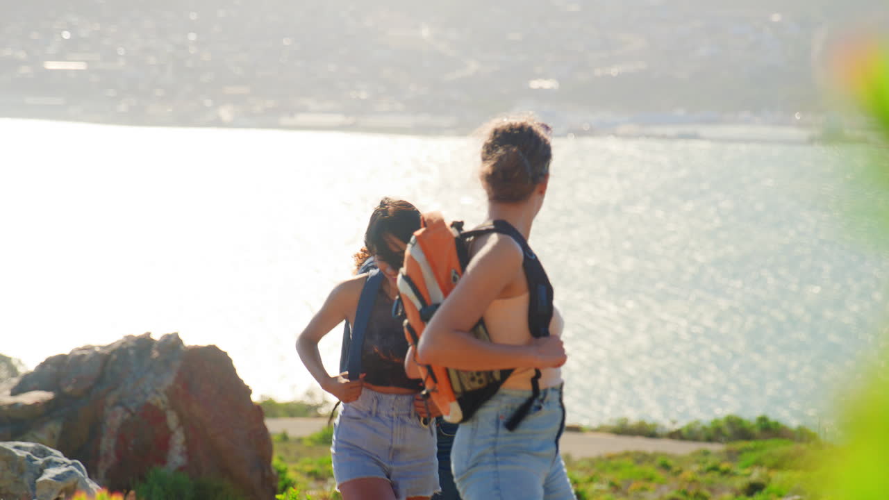 grupo de amigas con mochilas de vacaciones en una caminata por el campo en el camino costero
