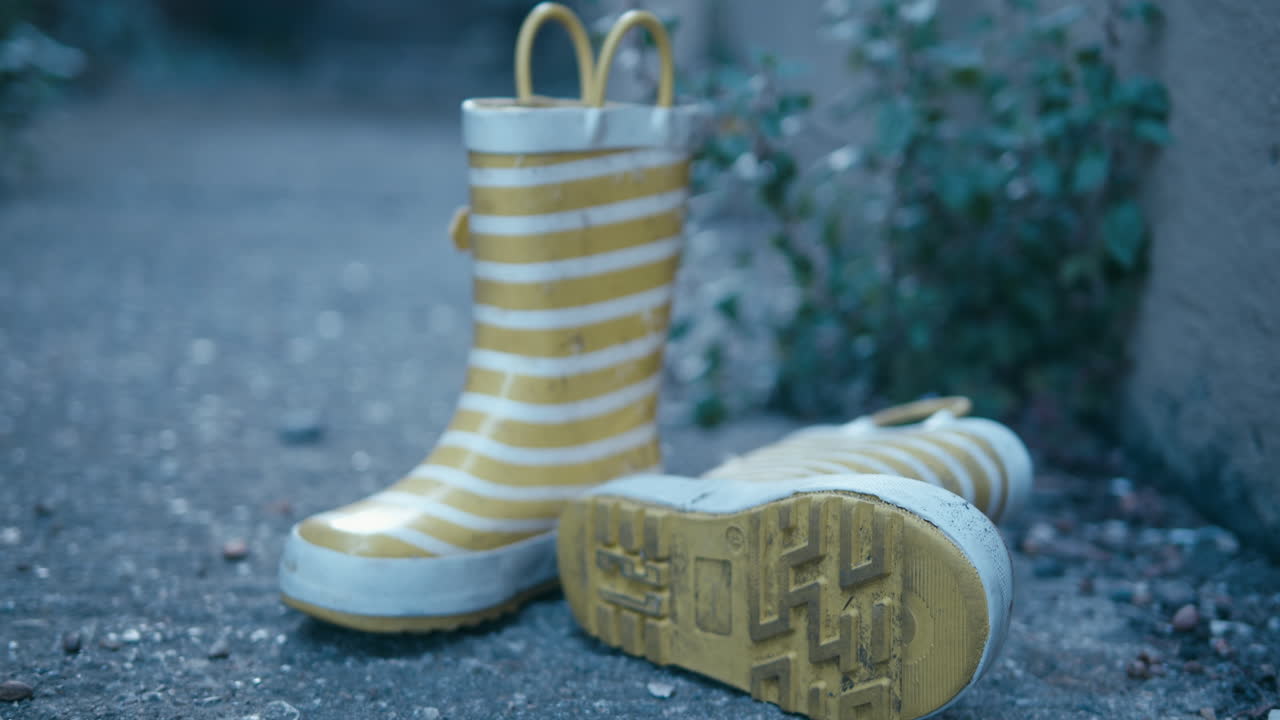 Slow pan past some yellow and white striped wellington boots.
