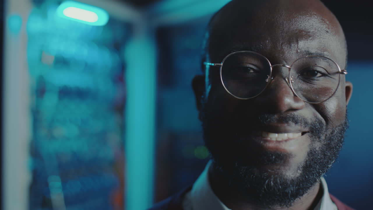 Close-up portrait of a smiling African American man in a tech environment
