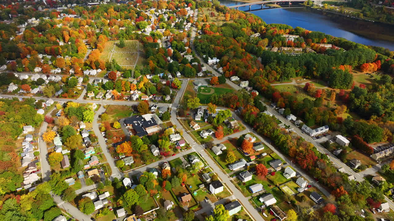 Residential area in the picturesque autumn weather. Aerial view on the town located on the river waterfront.