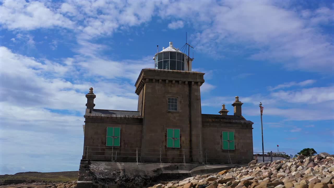 Blacksod Lighthouse in all its splendor, dolly shot of the beacon framed under dramatic blue sky. County Mayo