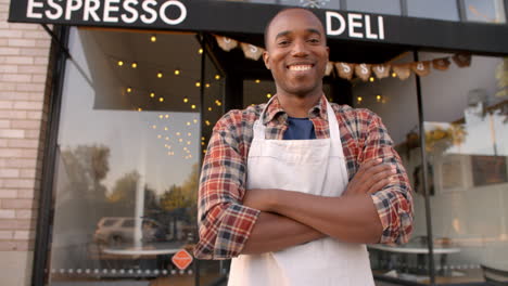 black male owner walks into focal plane outside coffee shop