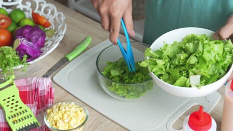 A-Man-Making-Salad,-Putting-Sliced-Lettuce-Into-Bowl