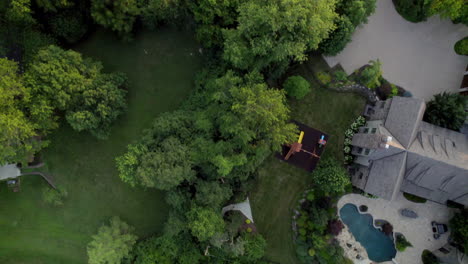 Top-down-aerial-view-of-a-beautiful-upscale-neighborhood-at-sunrise-in-the-summer-with-a-scroll-up