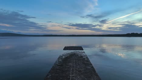 Slowly-flying-over-old-pier-that-is-slowly-sinking-over-time-in-Spain