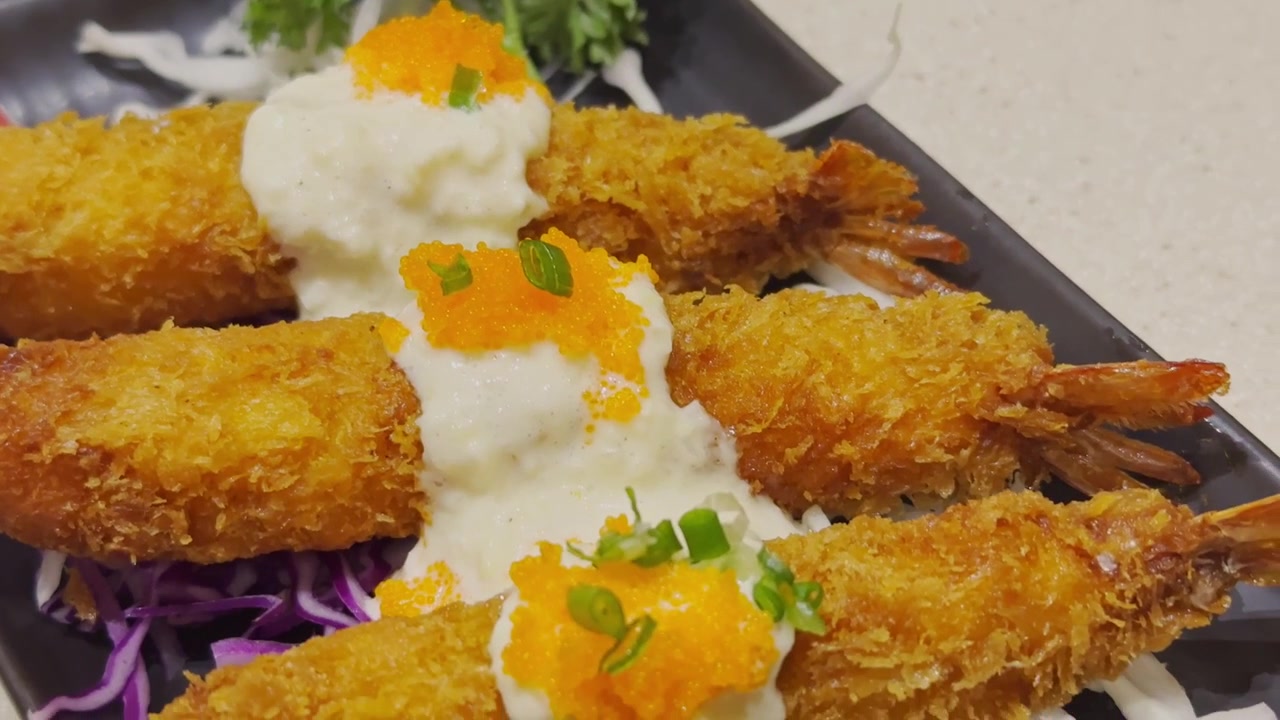 Video ravvicinato di tempura giapponese croccante splendidamente servita su un piatto tradizionale. Frutti di mare e verdure dorati in pastella presentati in un'autentica ambientazione culinaria