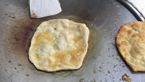 cocinar panqueques tailandeses exóticos, roti malaysian con diferentes rellenos en un mercado de tailandia. hacer rollo de roti de huevos en sartenes de metal calientes con aceite hervido. comida callejera de tailàndia. postre tailandés.