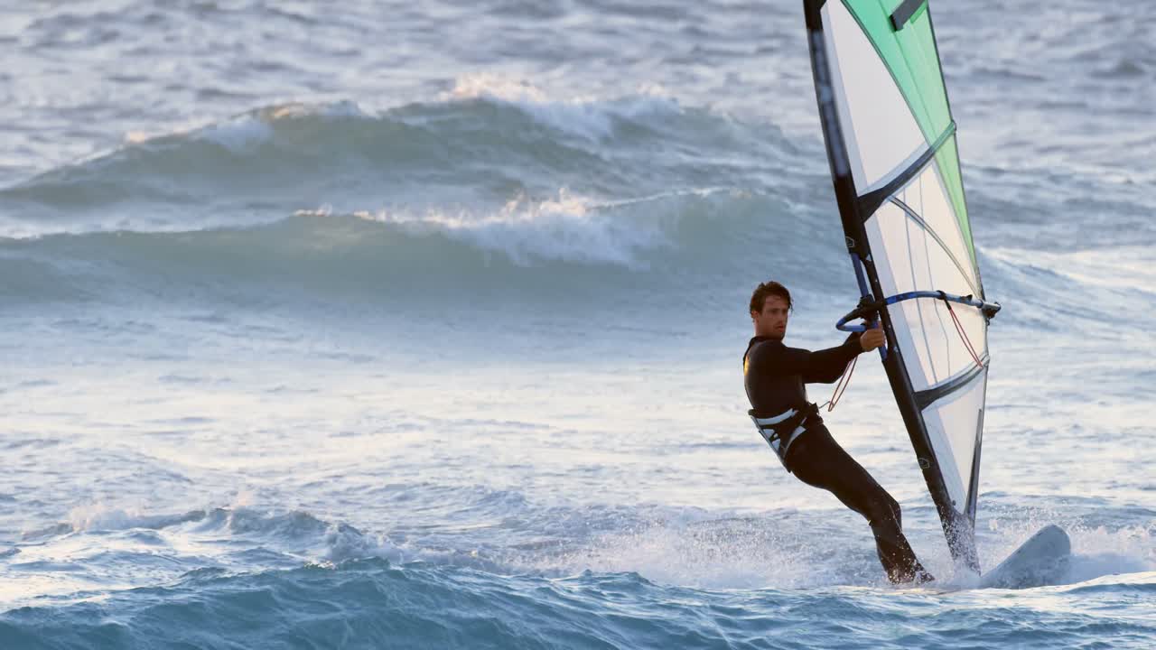 surfista masculino haciendo windsurf en la playa 4k