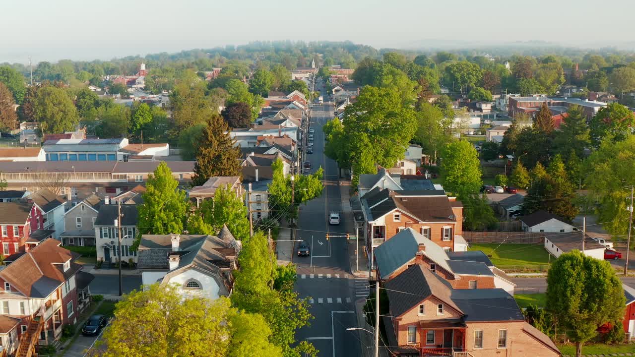 Beautiful aerial above traffic on street through quaint small town in USA