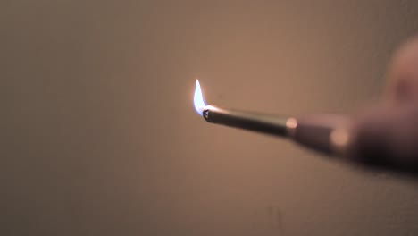 igniting a long lighter in front of white background